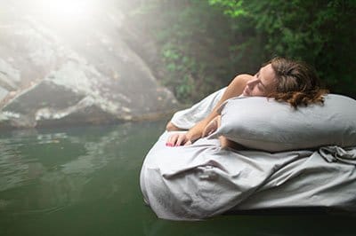 A hidden place. Sleeping woman in deep forest lies on airbed