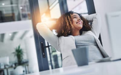 Shot of a young businesswoman taking a break at her office desk