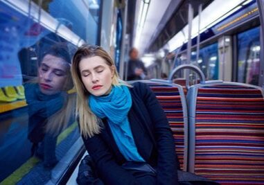 portrait of young woman sleeping inside subway train, feeling exhausted.lifestyle concept.