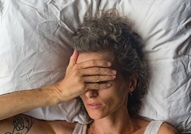 High angle close up  view of middle aged woman sleeping on pillow with hand over eyes (selective focus)