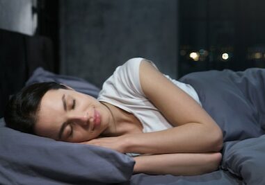 Young female sleeping peacefully in her bedroom at night, relaxing