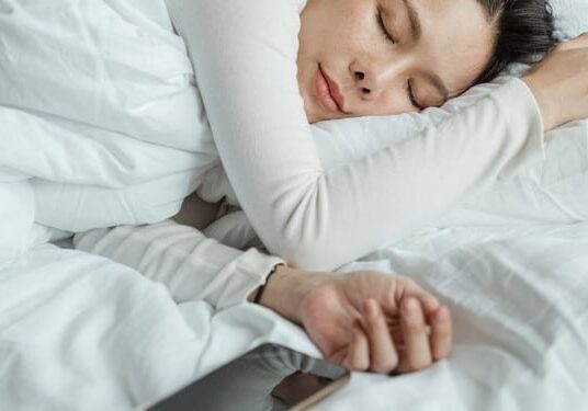 woman-sleeping-next-to-a-smartphone